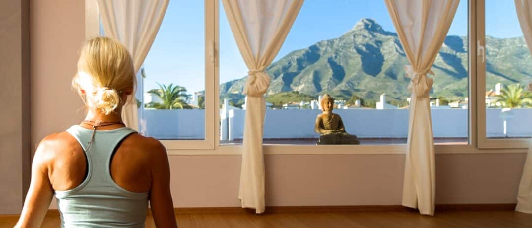 Yoga teacher sitting in a yoga studio in Marbella looking at the view